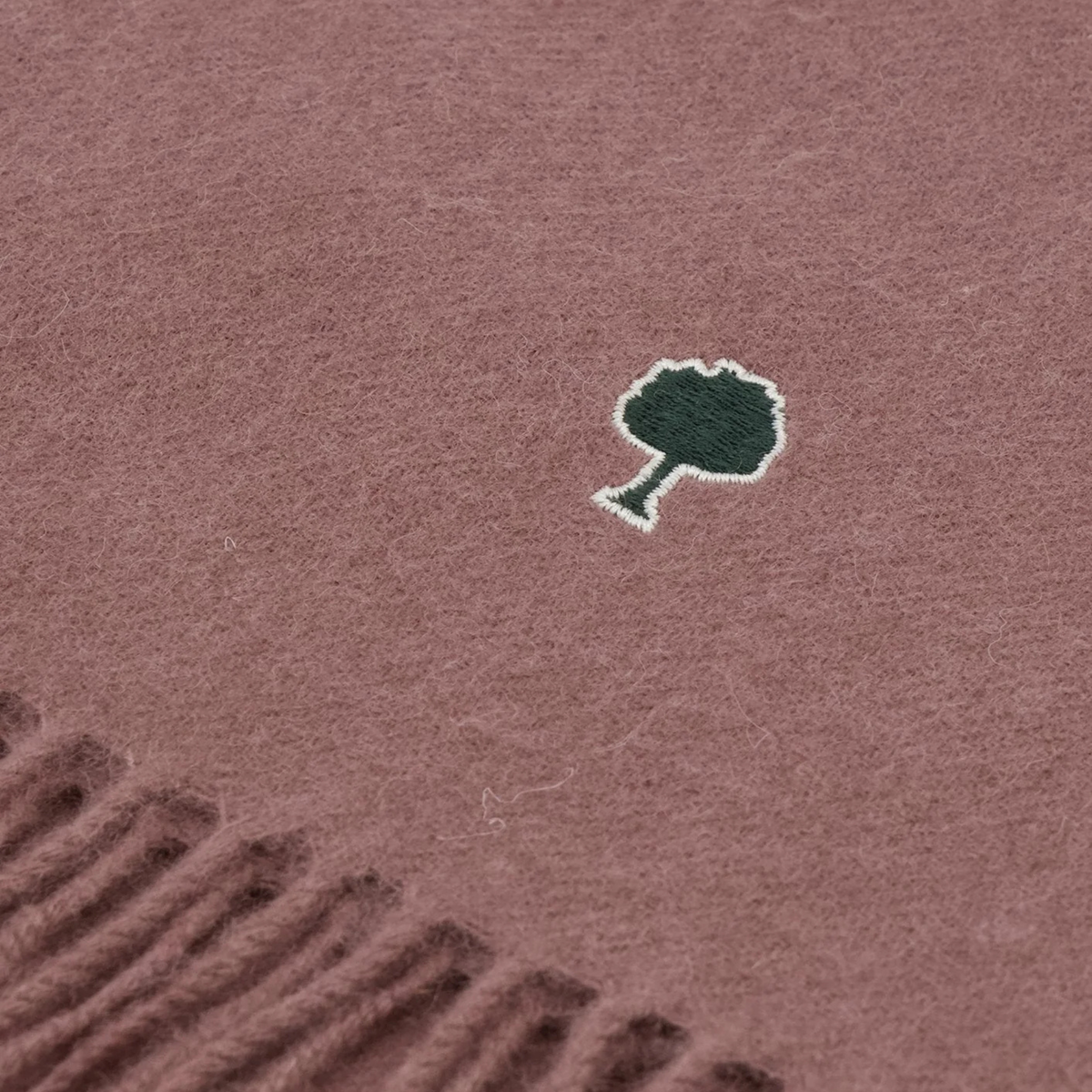 Détail de la laine grattée vieux rose et de l'arbre Faguo brodé vert sapin cerclé d'écru