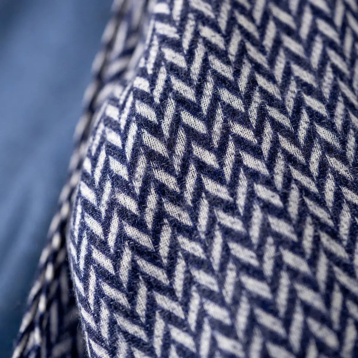 Macro du tissage chevron en laine, fine alternance de fils Bleu Marine et blancs sur le pan