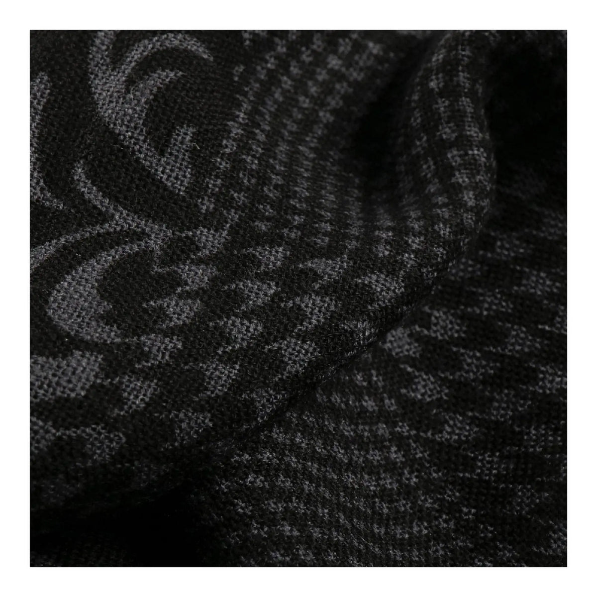 Gros plan du jacquard noir et gris, arabesques baroques et damier tissés