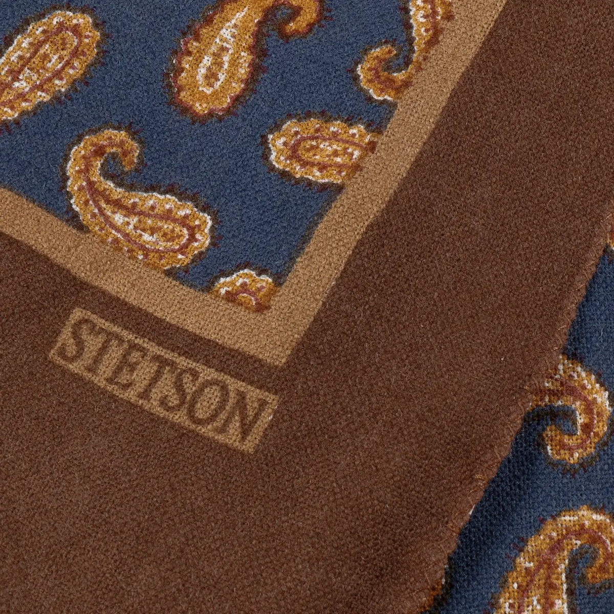Angle de l'écharpe : liseré camel, bordure brun chocolat et logo Stetson en cartouche