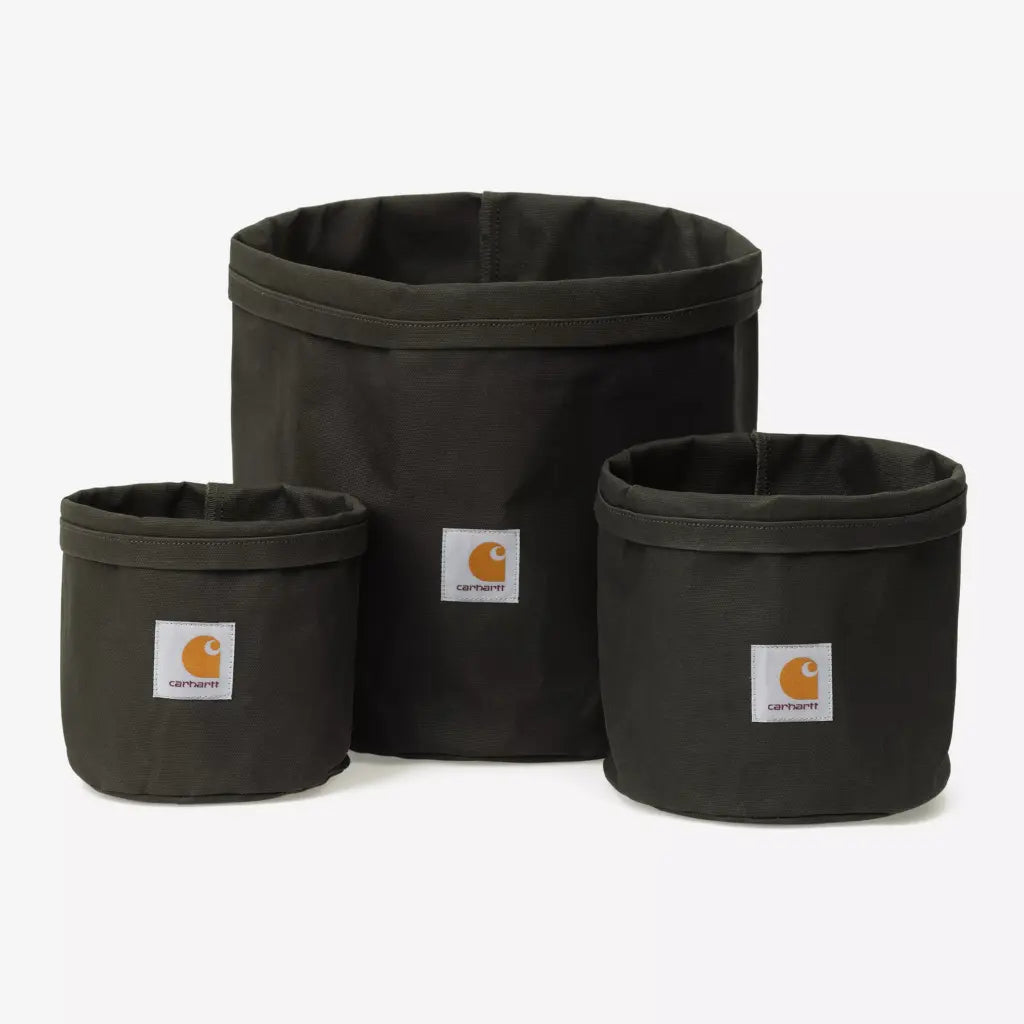 Trois cache-pots en toile kaki foncé de tailles différentes, bord roulé cousu et étiquette carrée blanche