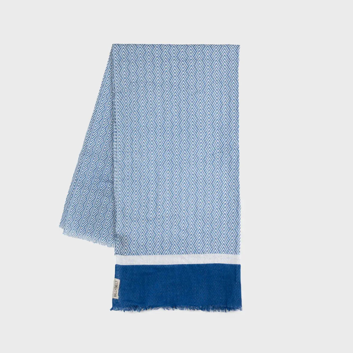 Foulard en coton plié à plat, chevrons bleus et blancs, large bande bleu roi en bout et franges effilochées