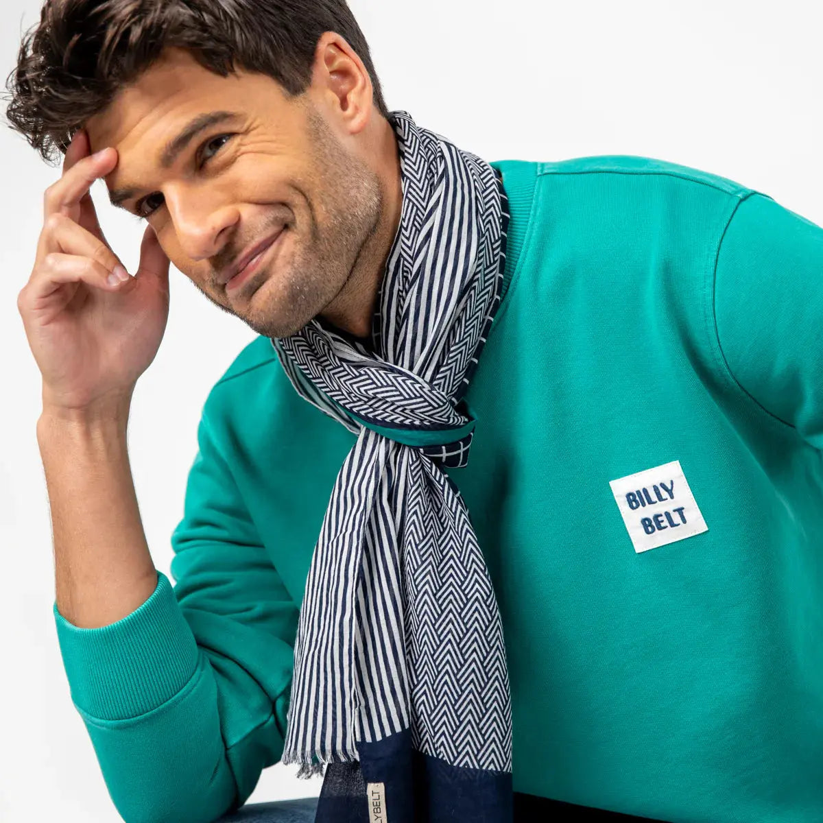 Foulard rayé Bleu Marine et blanc noué au cou, le motif à chevrons apparaissant sur l'autre face du carré