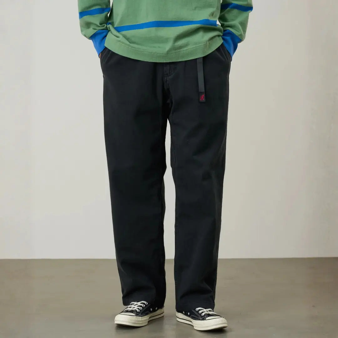 G-pant Straight Fit noir porté de près, taille élastiquée, sangle grise à boucle et jambe droite jusqu'à la cheville