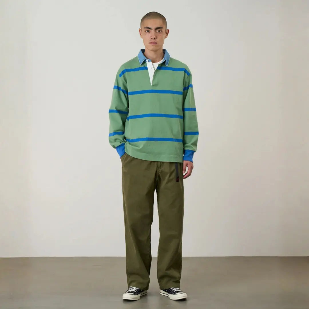 Silhouette complète : G-pant Straight Fit olive porté avec un polo rugby rayé vert et des baskets basses