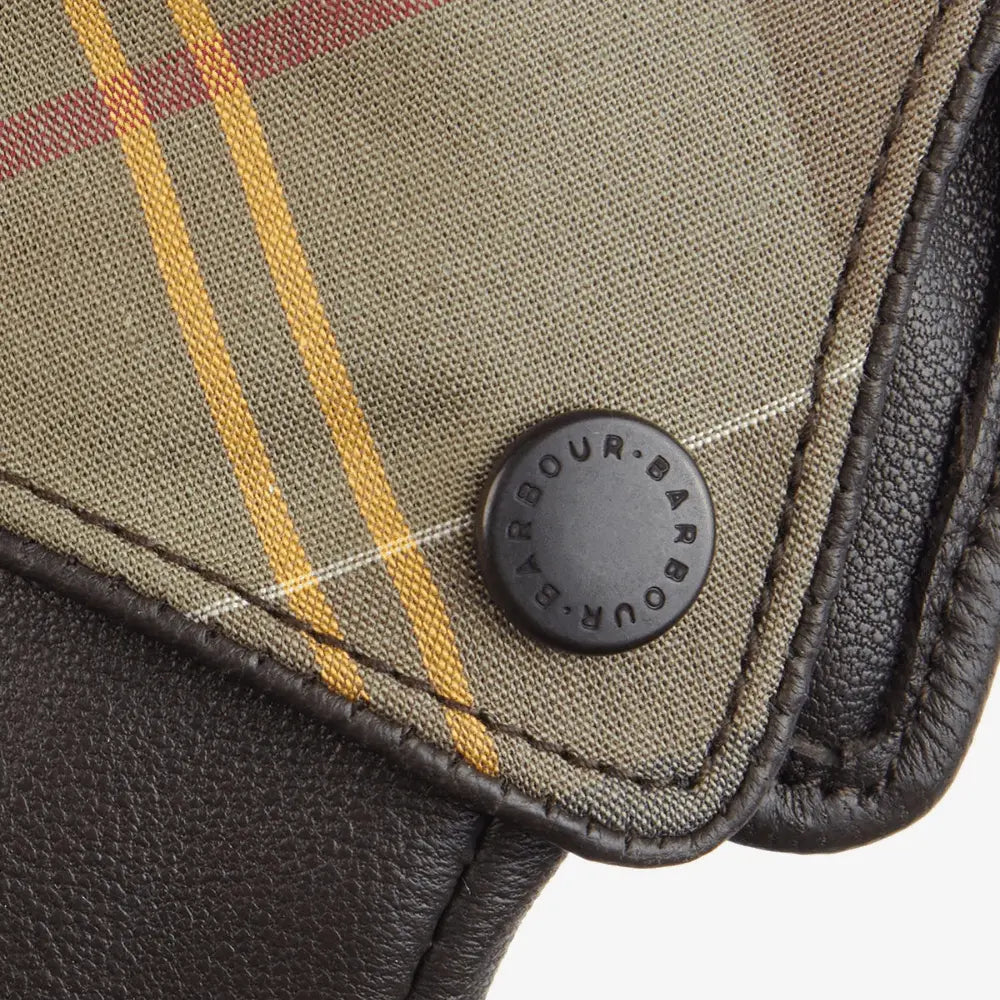Macro du revers tartan et de la pression noire gravée Barbour, surpiqûres du cuir