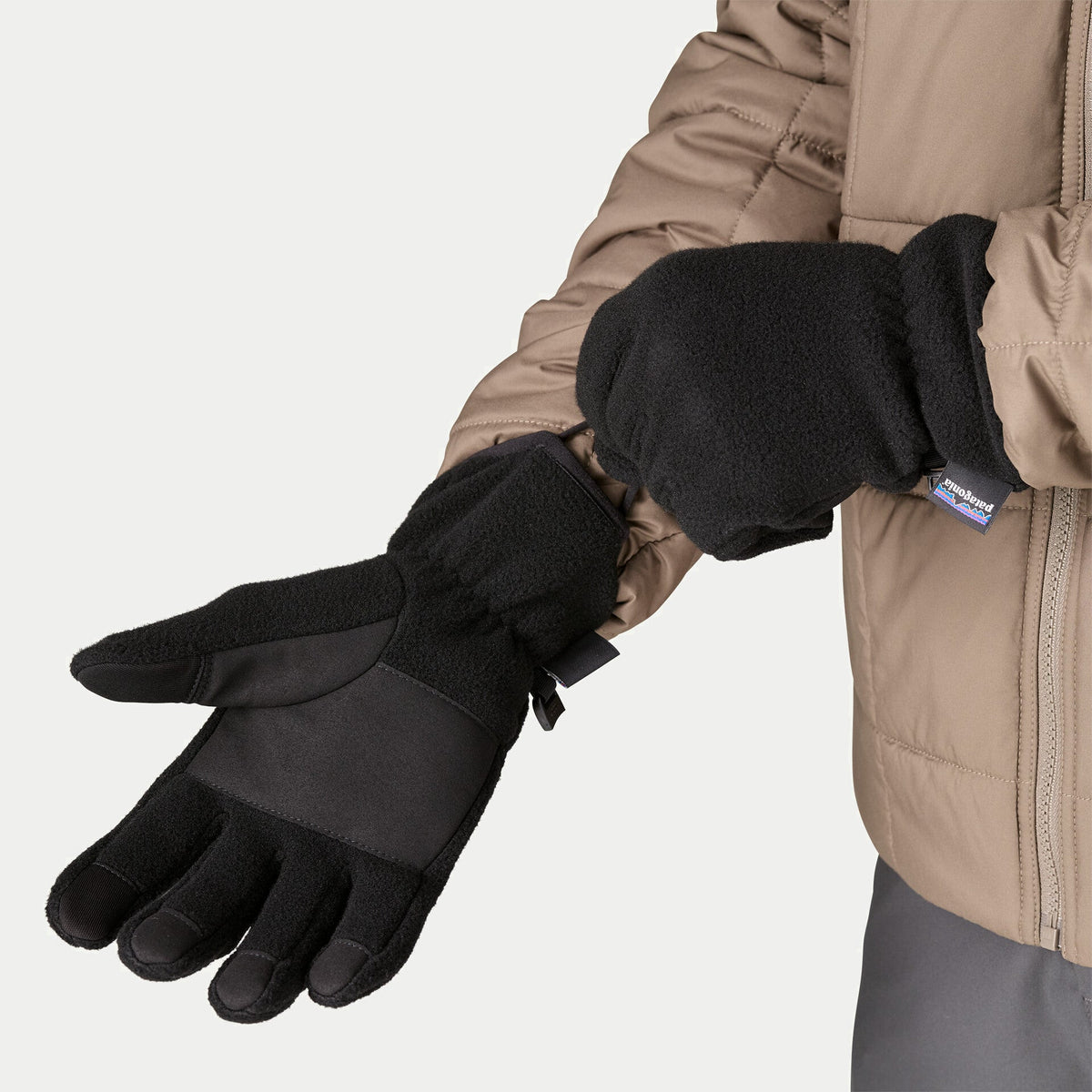 Gants Synchilla Fleece noirs Patagonia - vue portée, paume ouverte montrant les bouts de doigts tactiles et le renfort
