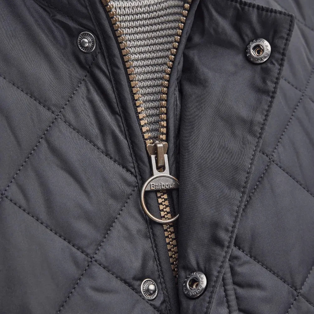 Zip du gilet Lowerdale marine entrouvert, tirette anneau gravée Barbour et pressions nickel du rabat