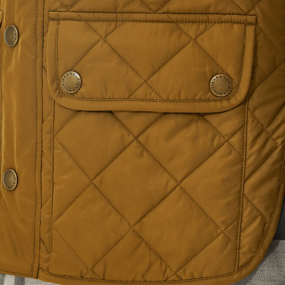 Détail de la poche à rabat du gilet Lowerdale ocre, pressions laiton doré gravées Barbour