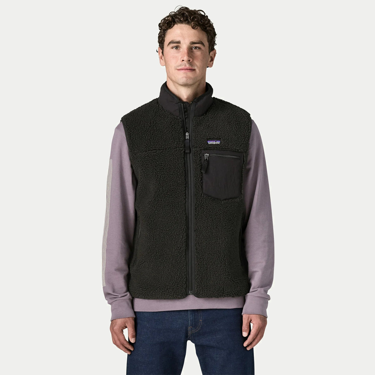 Gilet Retro-X Patagonia noir porté et zippé sur un sweat : col montant doublé, poche poitrine et poches latérales zippées