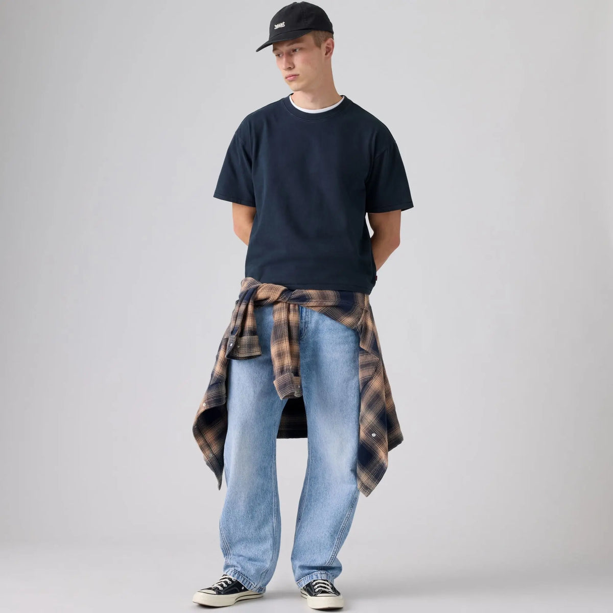 Jean Levi's Baggy Barrel Running The Race porté avec un t-shirt marine et une chemise à carreaux nouée à la taille