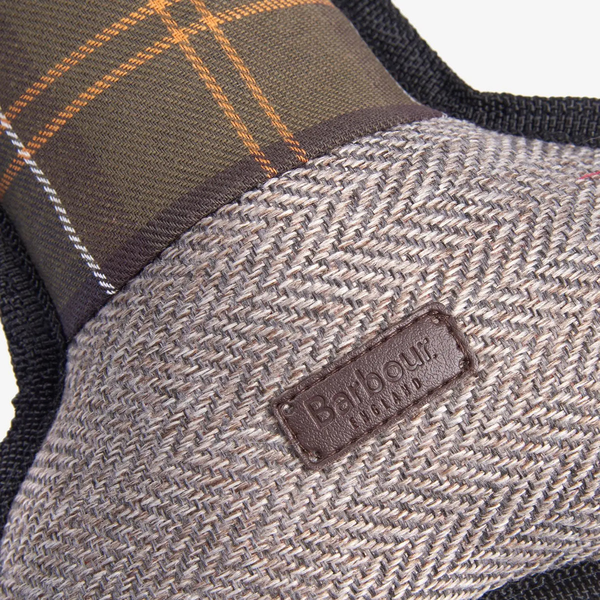 Gros plan du tweed chevron et du tartan olive-ocre du jouet os, patch cuir Barbour England