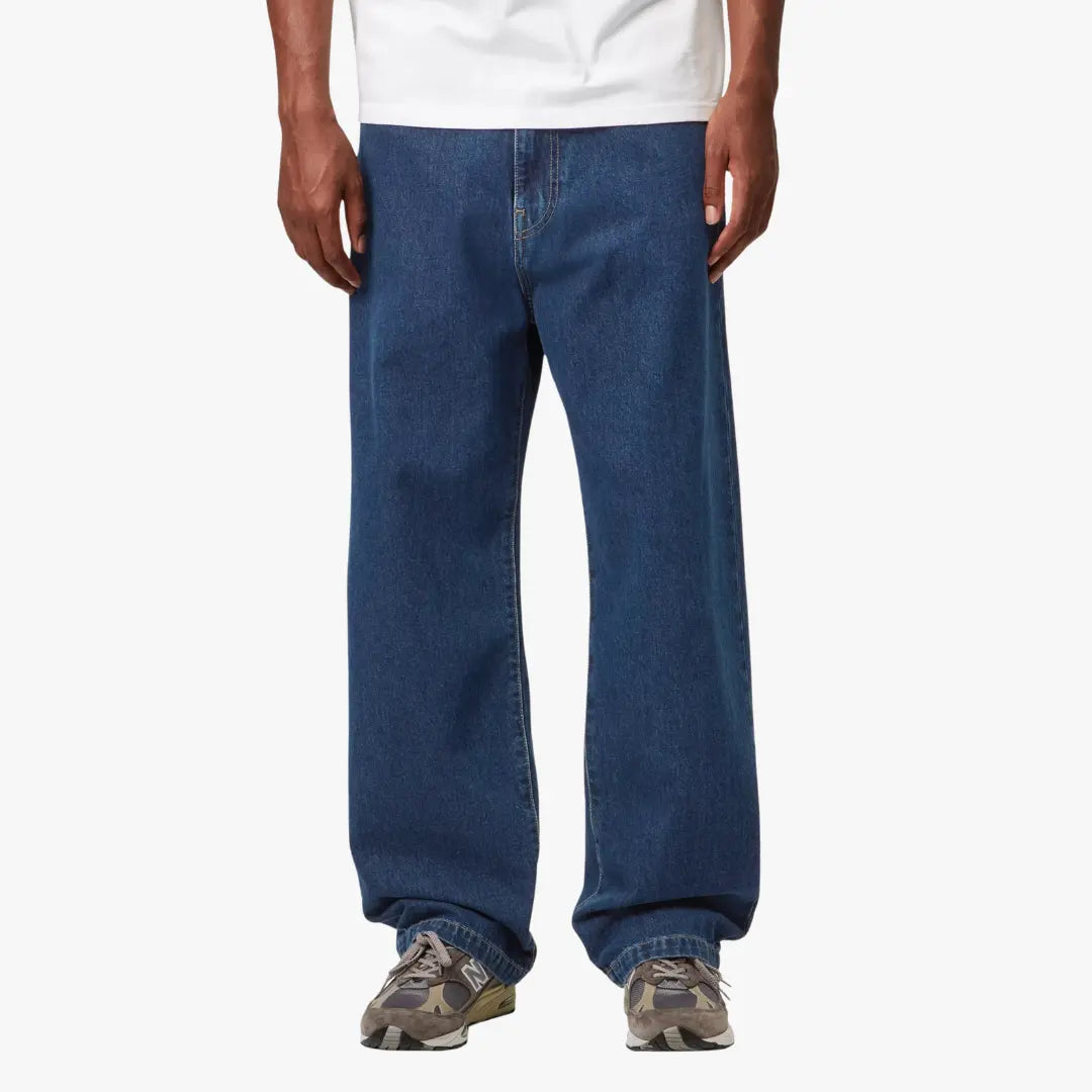 Landon Pant Blue Stone Washed porté de face, coupe ample bleu moyen dont le bas casse nettement sur la chaussure
