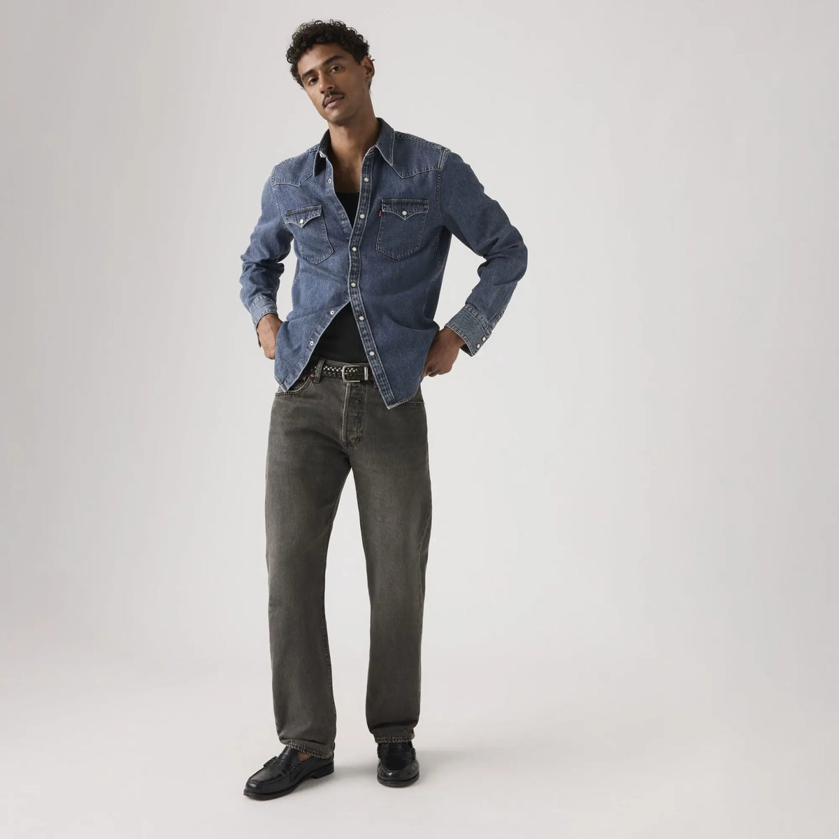 Jean Levi's 501 Original Oak Nights porté de face avec une chemise en jean bleue et des mocassins noirs