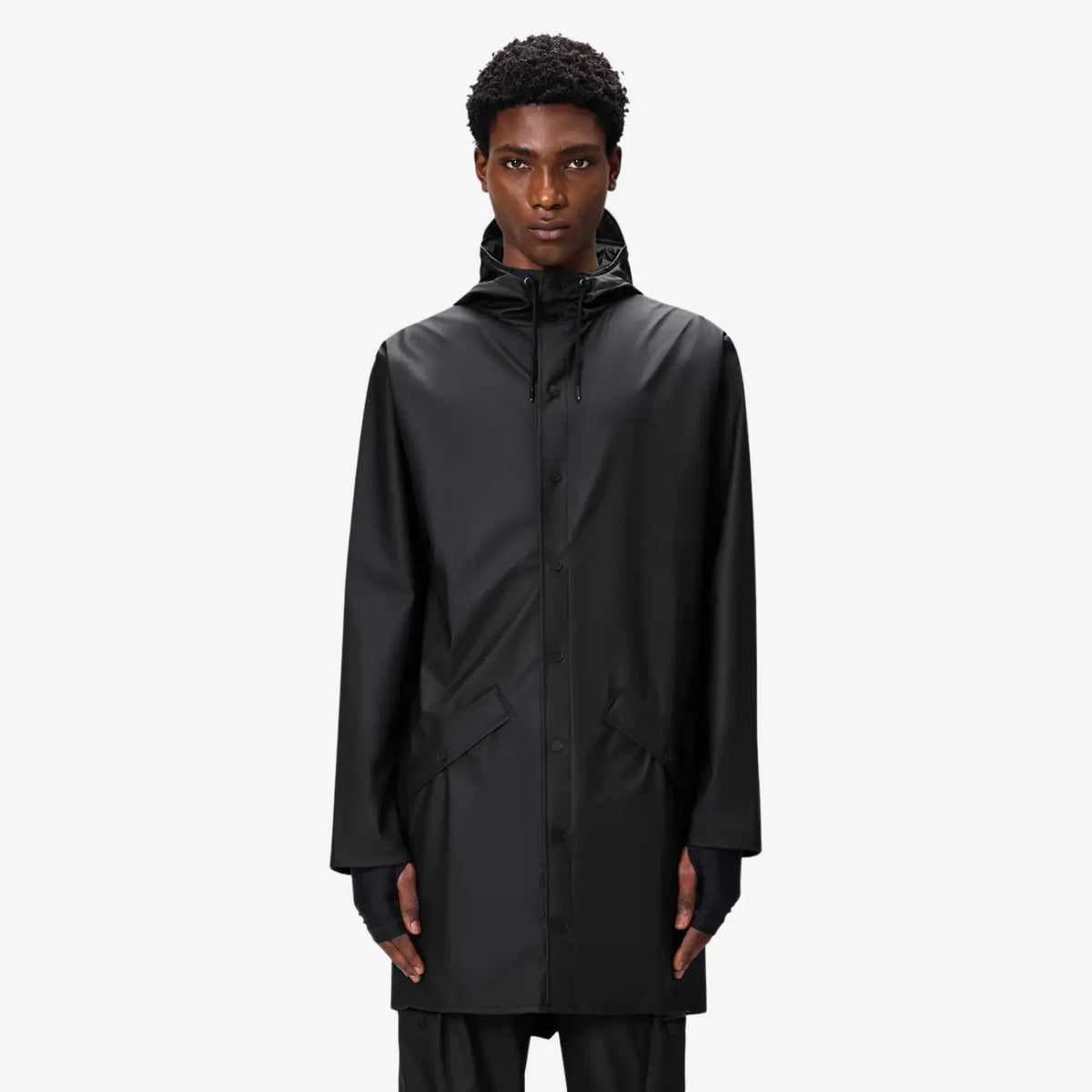 Long Jacket noire portée fermée, col haut cordé et longueur couvrant largement les hanches