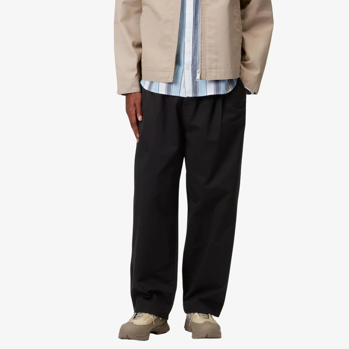 Marv Pant noir porté de face sous une veste beige, volume ample tenu de la cuisse à la cheville