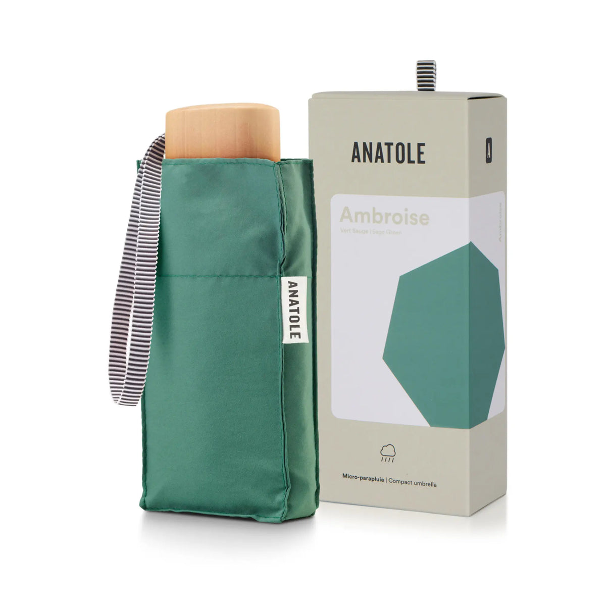Mini parapluie Ambroise vert sauge rangé dans sa housse, poignée en bois clair et coffret Anatole en arrière-plan