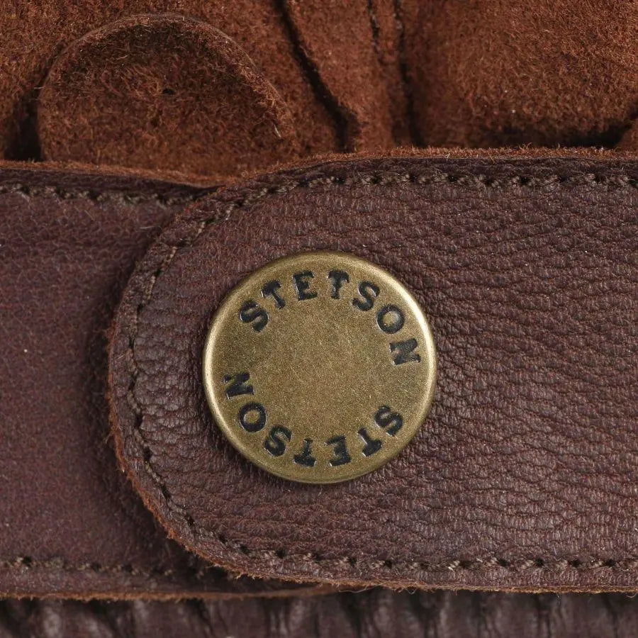 Détail de la patte de poignet marron et de son bouton-pression laiton gravé