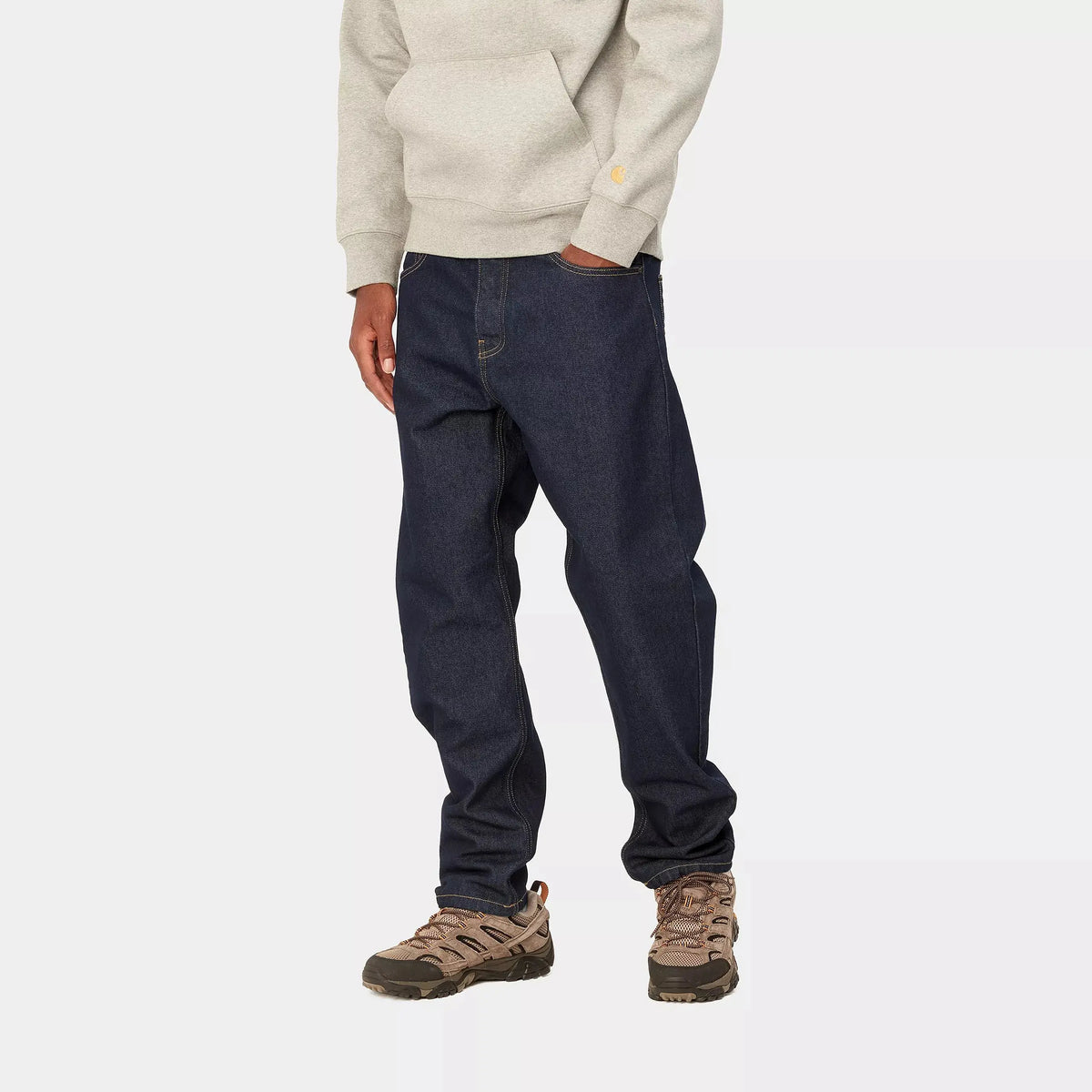 Newel Pant Blue One Wash porté de trois-quarts, couture latérale droite sur un indigo sombre et uniforme.
