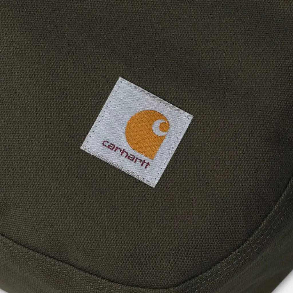 Gros plan du patch carré cousu sur la toile vert olive du coussin pour chien, trame du tissage bien visible