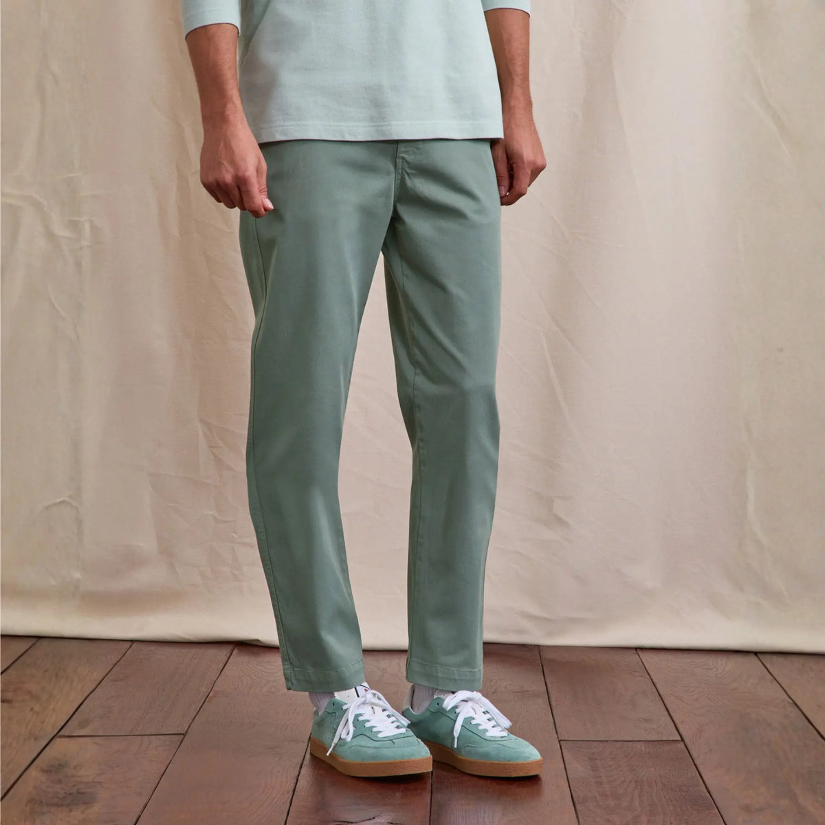 Pantalon Brix Regular vert clair porté de face, jambe droite tombant sur des baskets vertes