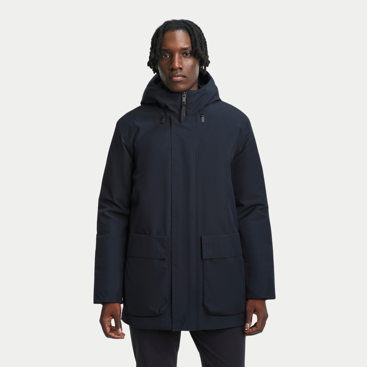Parka matelassée noire portée de face, deux grandes poches plaquées