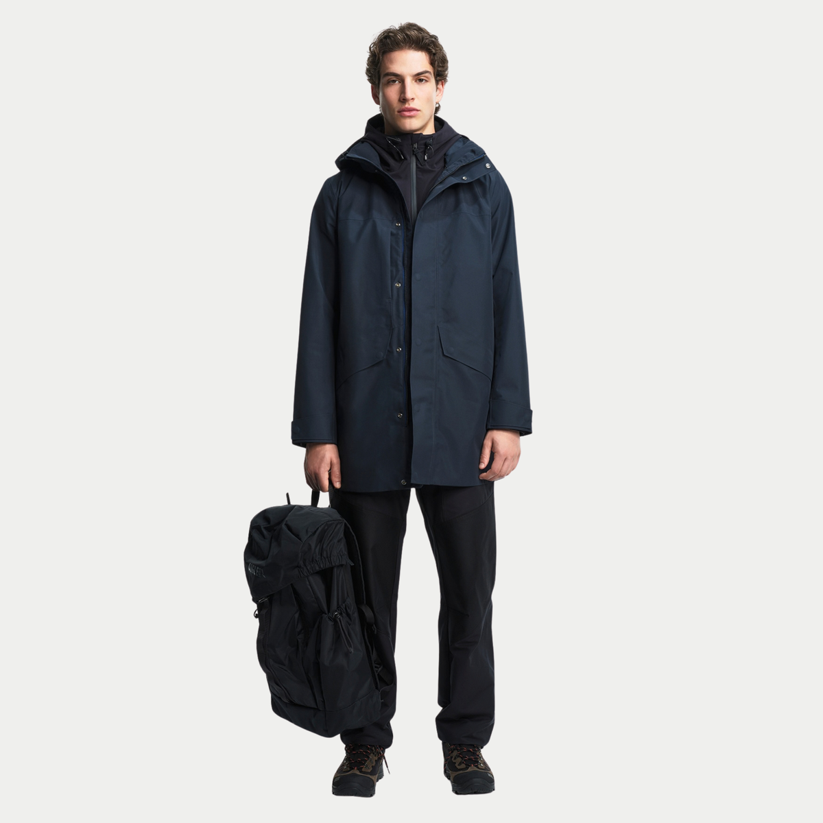 Parka T-KIT bleu marine portée en pied avec un sac à dos