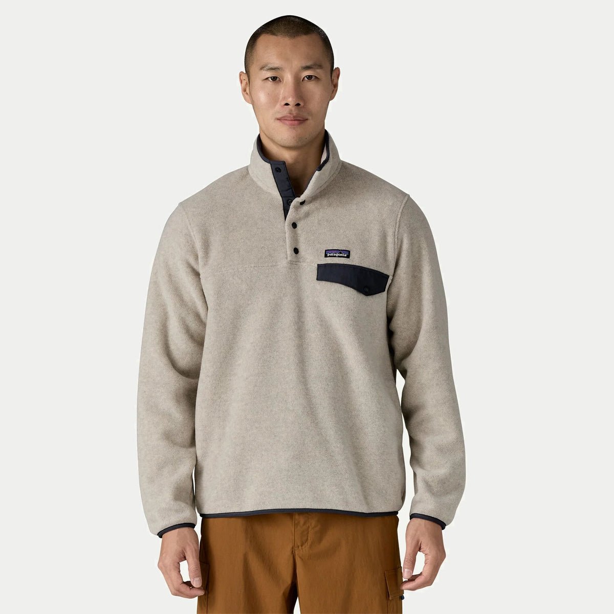 Polaire Snap-T Patagonia portée de face, col montant ouvert et poche poitrine nylon marine sur polaire beige avoine chiné
