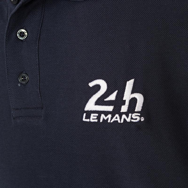 Gros plan du logo brodé blanc 24h Le Mans et de la patte à trois boutons du polo bleu marine