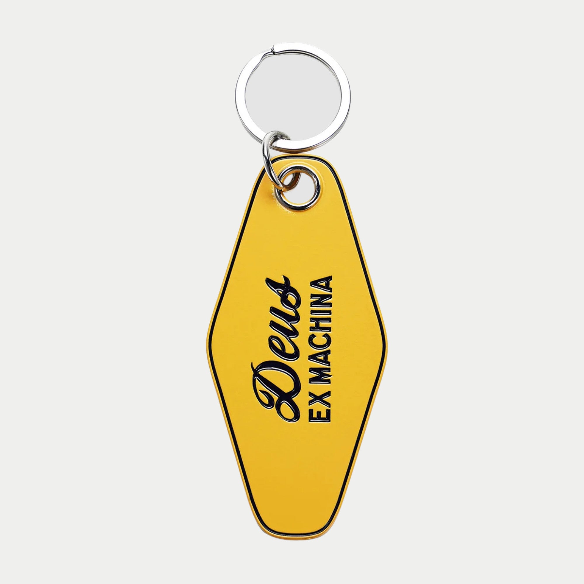 Porte-clés Biarritz émail jaune d'or vif, recto : Deus en cursive et EX MACHINA en capitales noires, anneau chromé