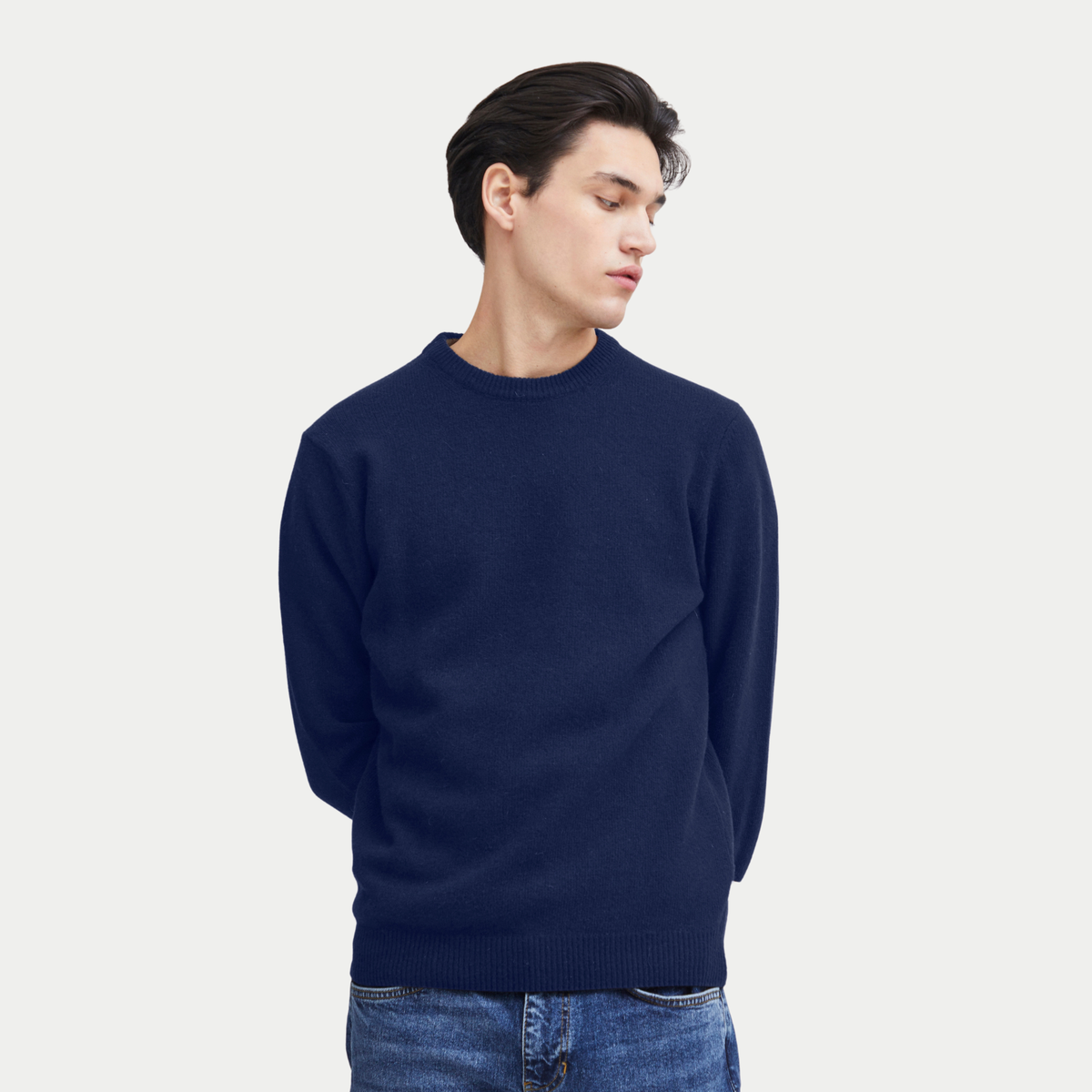 Pull en laine d'agneau bleu marine porté de face sur un jean, col rond et bas côtelé