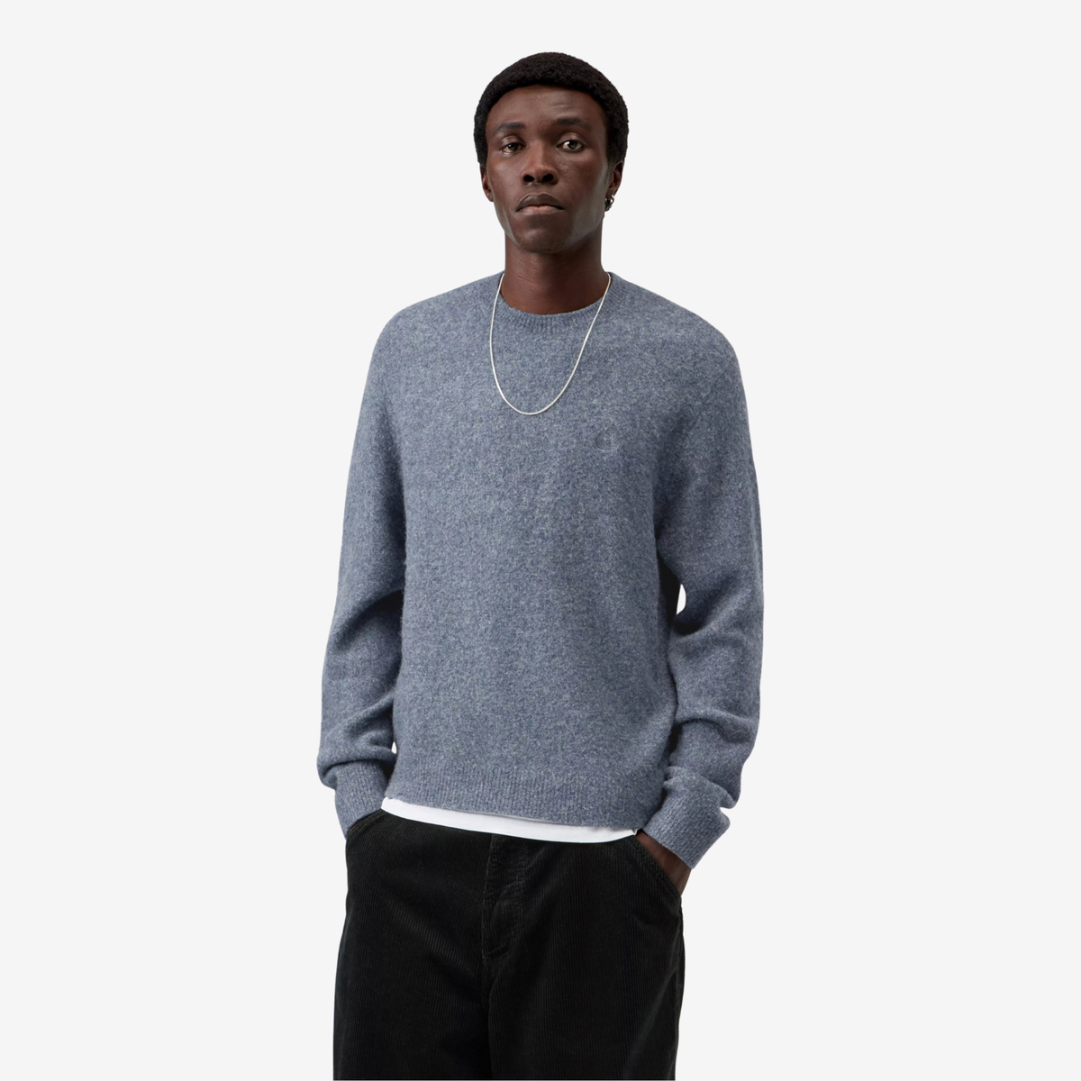 Pull Curtis Carhartt WIP bleu gris chiné porté de face, maille brossée duveteuse sur un pantalon en velours noir