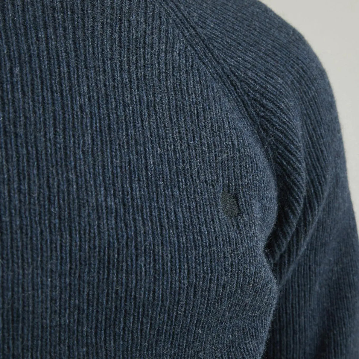 Macro de la maille côtelée bleue du pull Frehel au niveau de l'emmanchure raglan