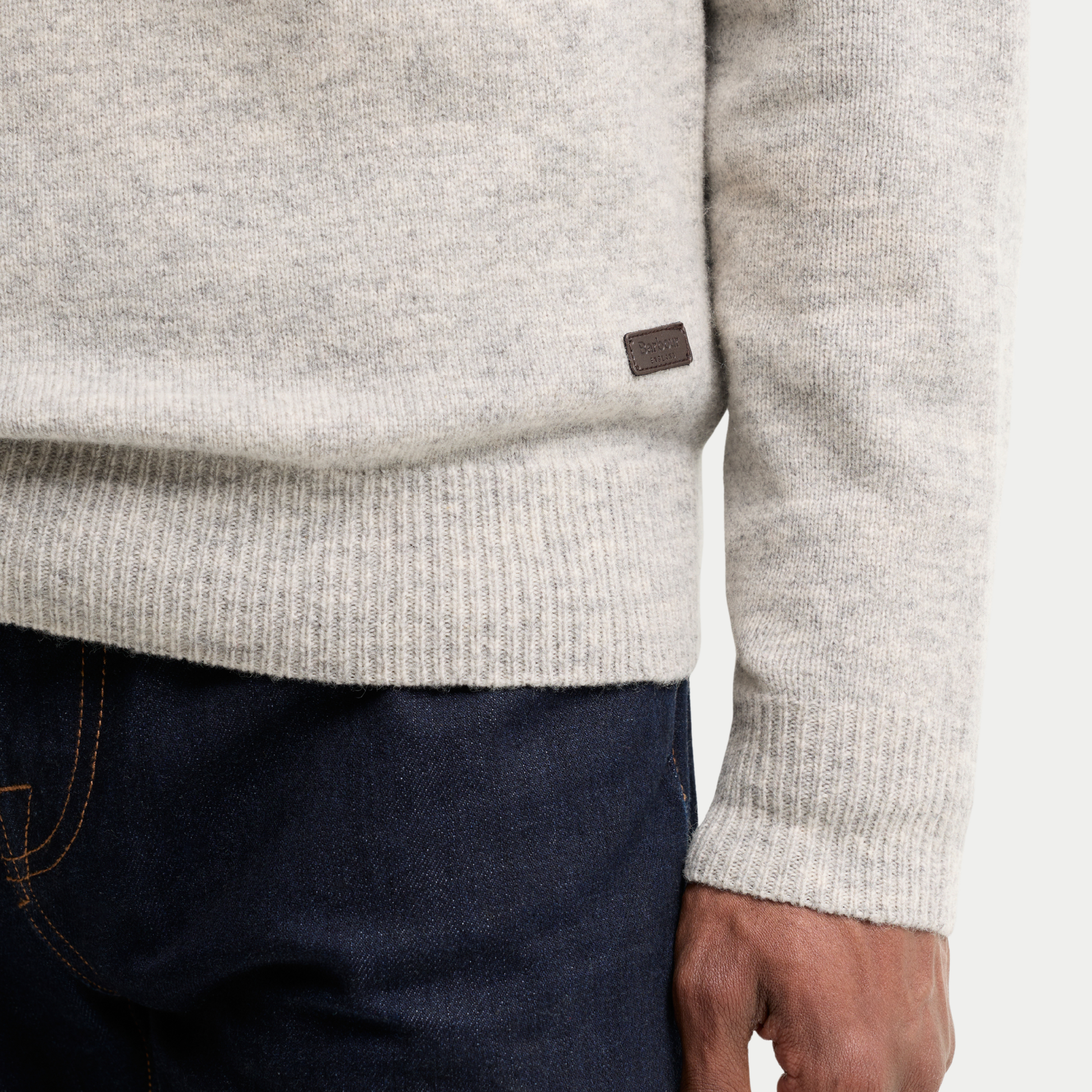 Détail du bas de pièce côtelé du Pull Barbour Essential Patch Light Grey Marl et de sa plaque Barbour