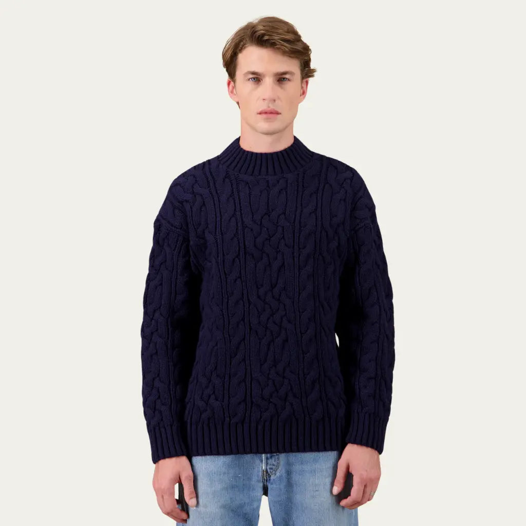 Pull Ohannes Bleu Marine porté de face, col montant côtelé et torsades sur le corps et les manches