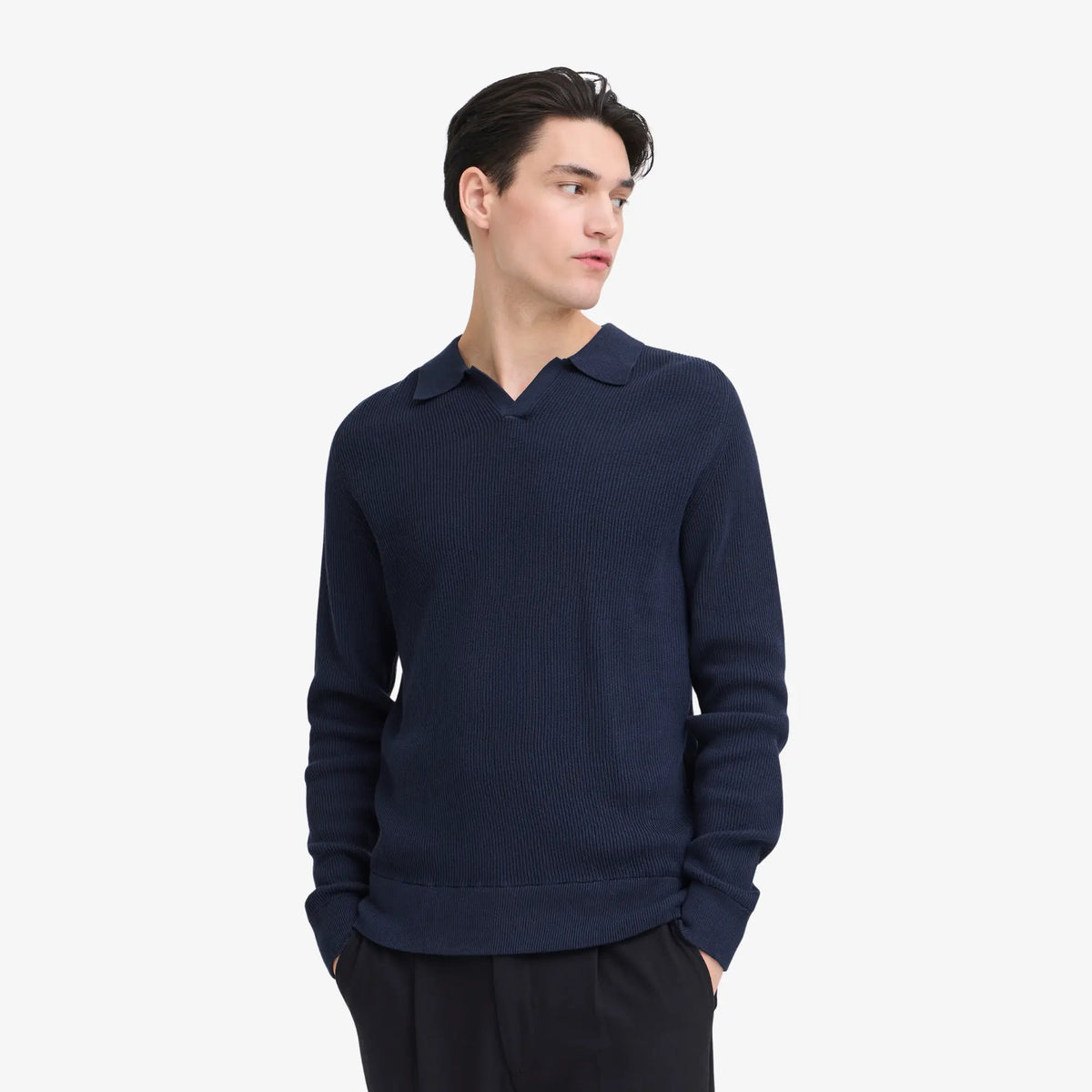 Pull polo bleu marine porté avec un pantalon noir, bord-côte de taille et poignets larges