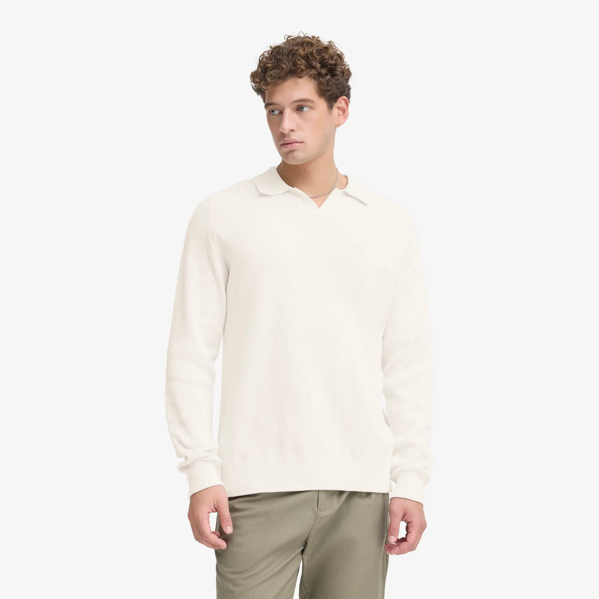 Pull polo écru porté avec un pantalon vert kaki, bas de corps et poignets en bord-côte