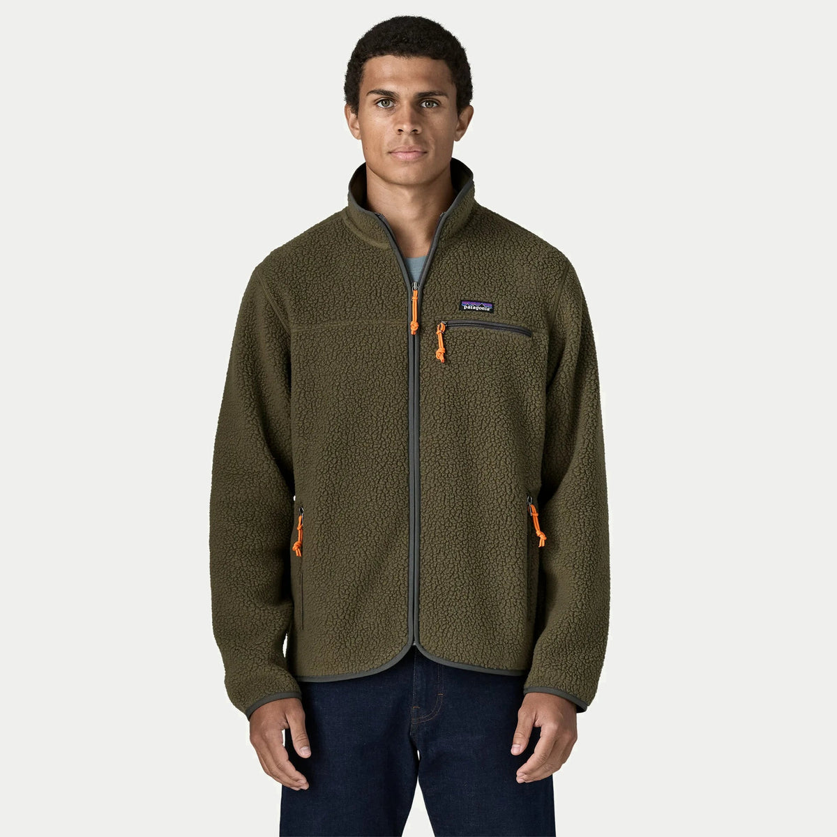 Retro Pile Jacket Patagonia vert olive portée de face, liserés gris ardoise et trois poches zippées à tirettes orange