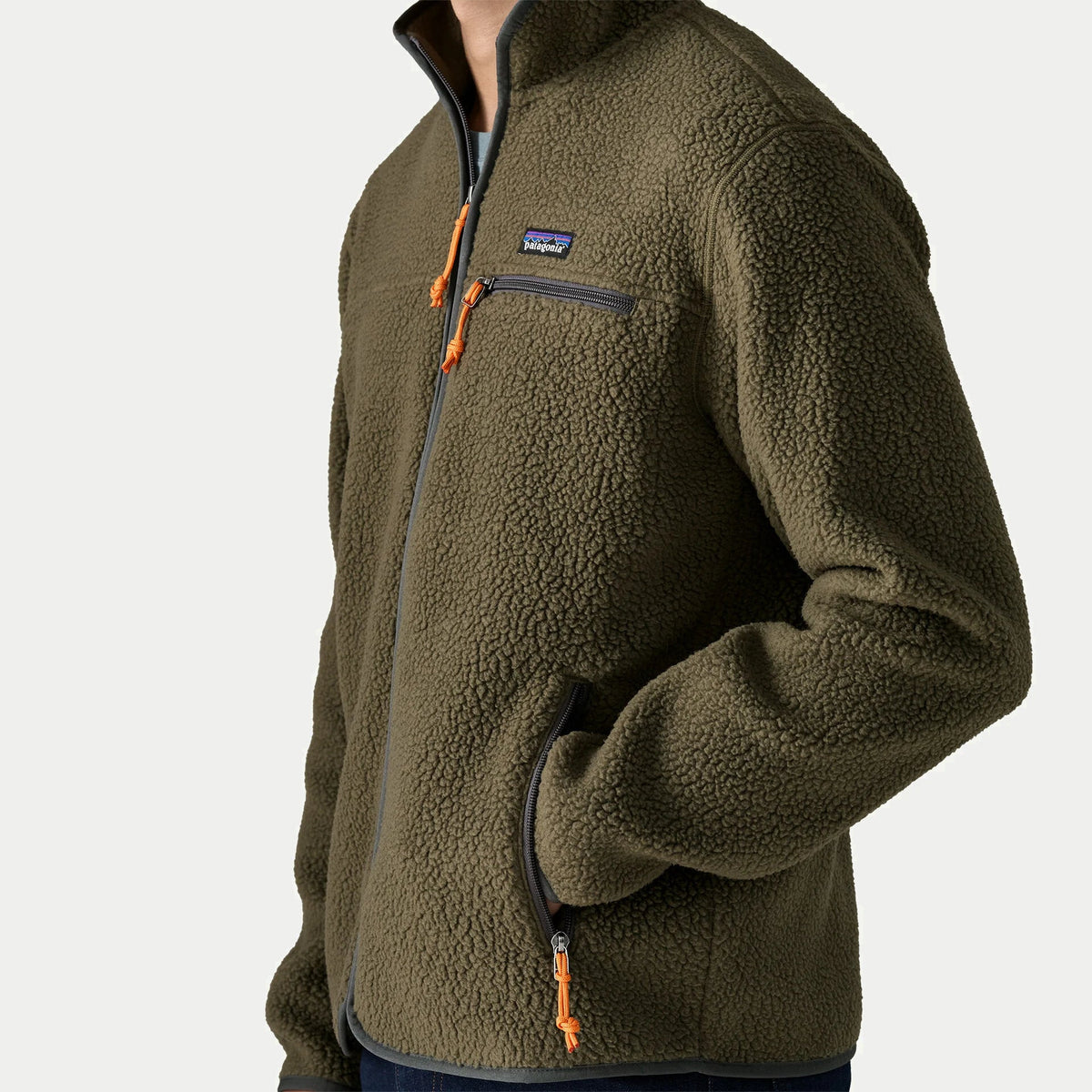 Détail du sherpa Polartec de la Retro Pile Patagonia vert olive : poche poitrine zippée et tirette cordon orange