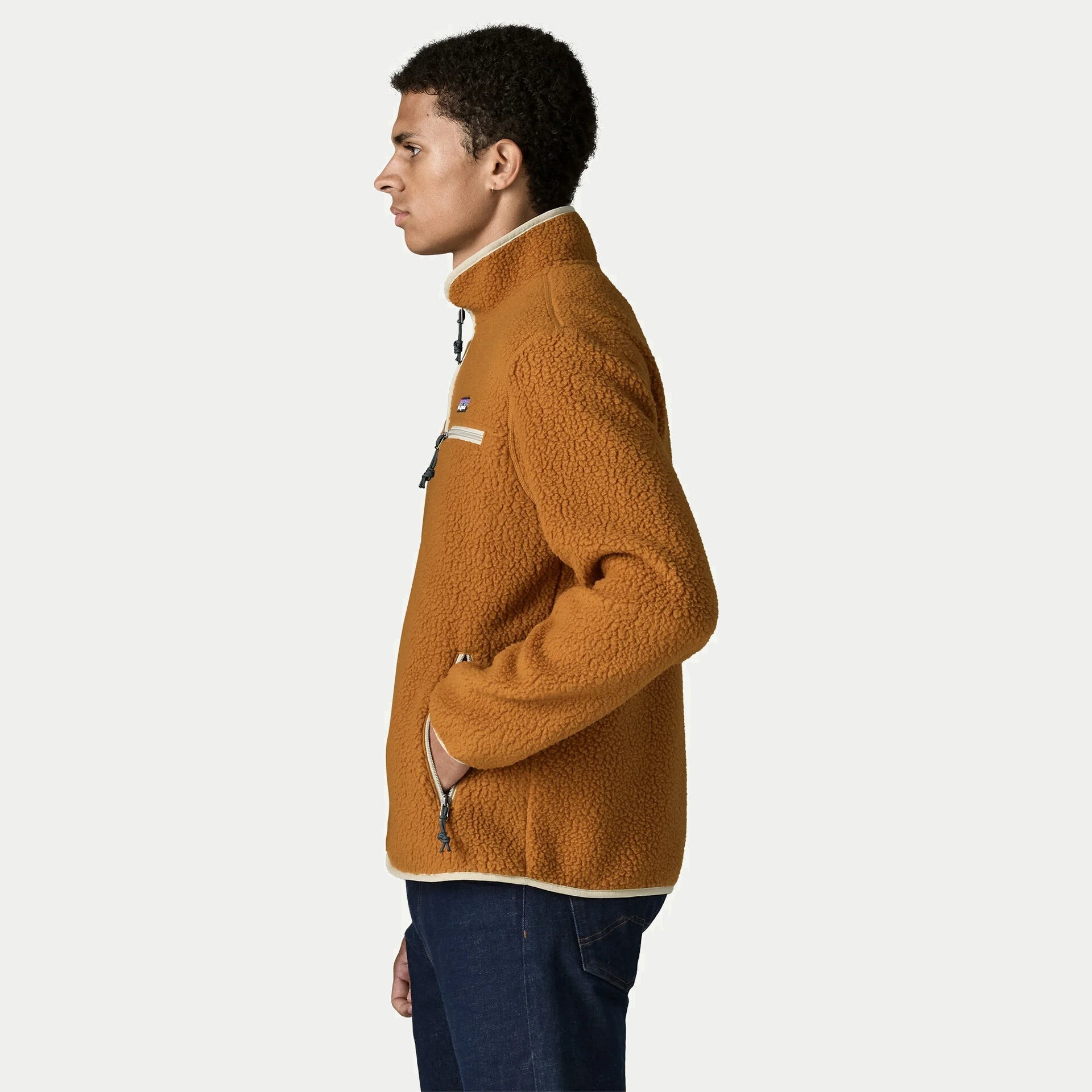 Veste polaire Retro Pile Cinnamon Brown Patagonia de profil, main dans la poche basse zippée, col montant bordé crème