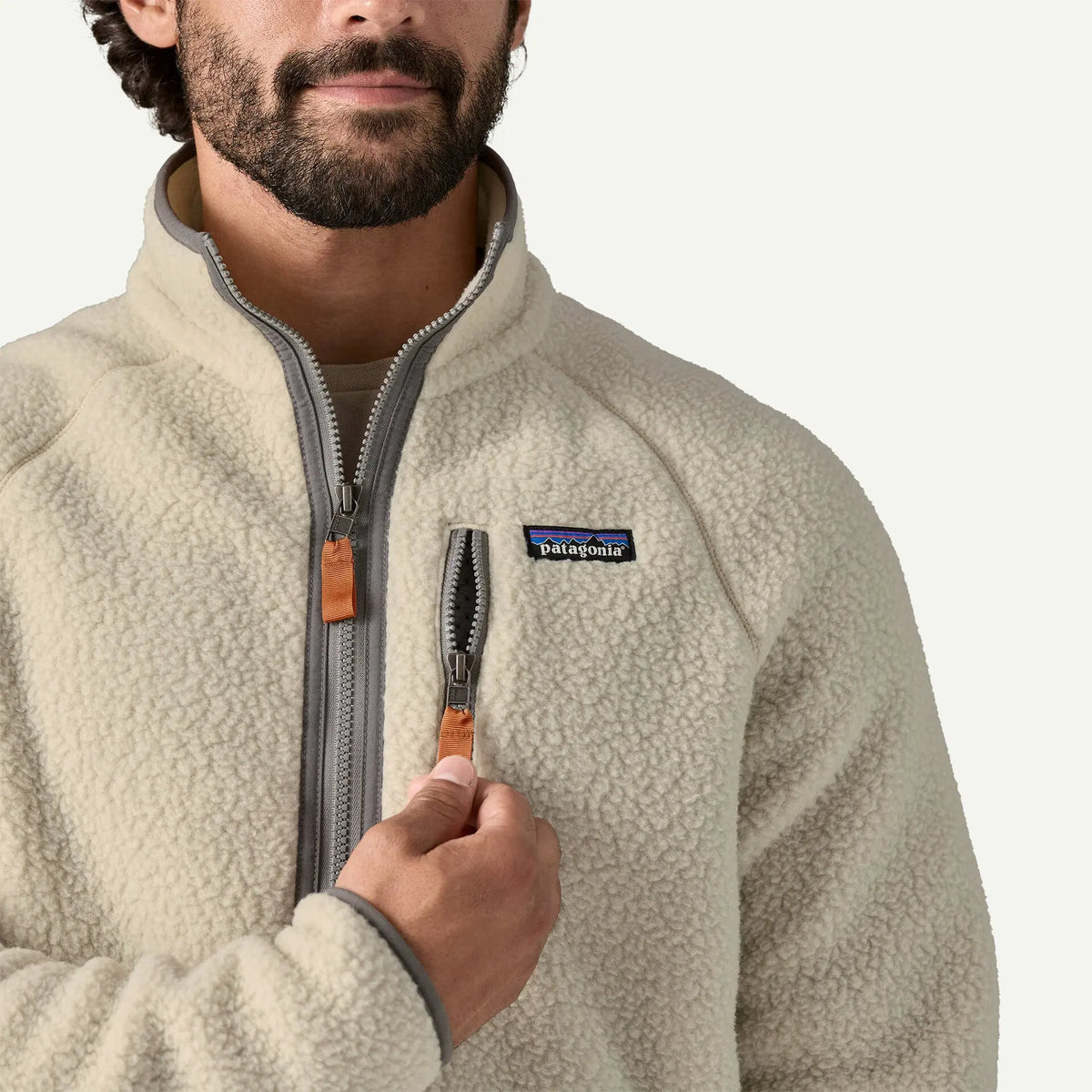 Gros plan du buste du Retro Pile Pelican : boucle dense du sherpa et tirettes caramel