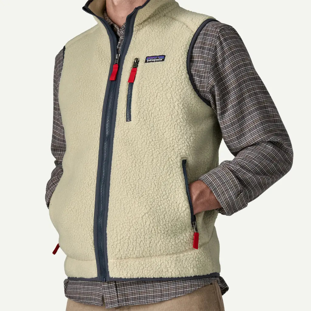 Gilet Retro Pile Pelican Patagonia porté de trois-quarts, main dans la poche latérale zippée à tirette rouge