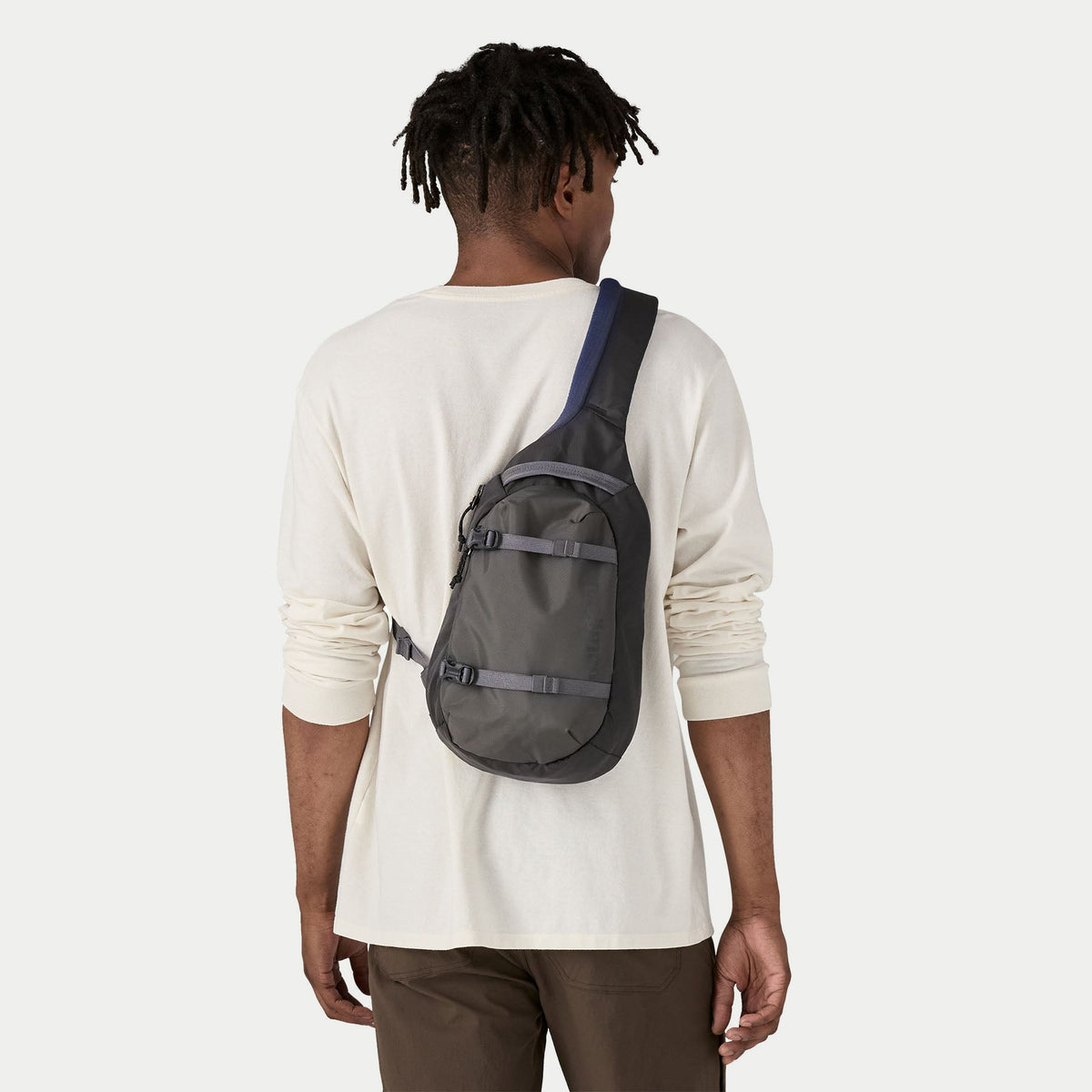 Atom Sling 8L Smolder Blue Patagonia porté en bandoulière dans le dos, sangle en travers du buste