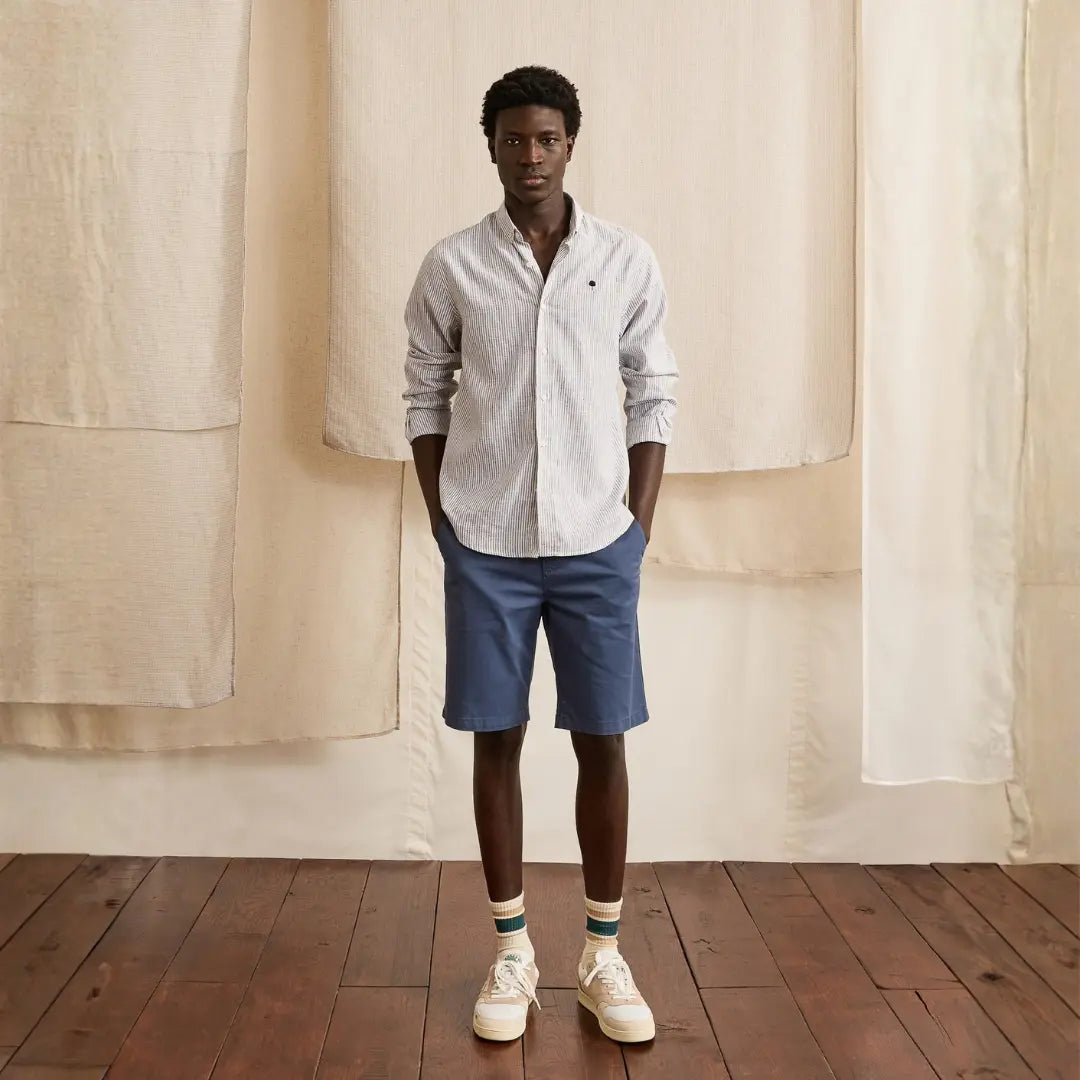 Short Saulieu bleu marine porté en pied avec une chemise rayée et des baskets écrues