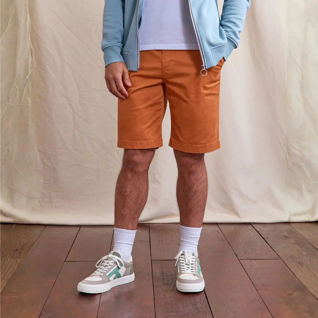 Short Saulieu brique porté avec un sweat zippé bleu ciel et des baskets blanches