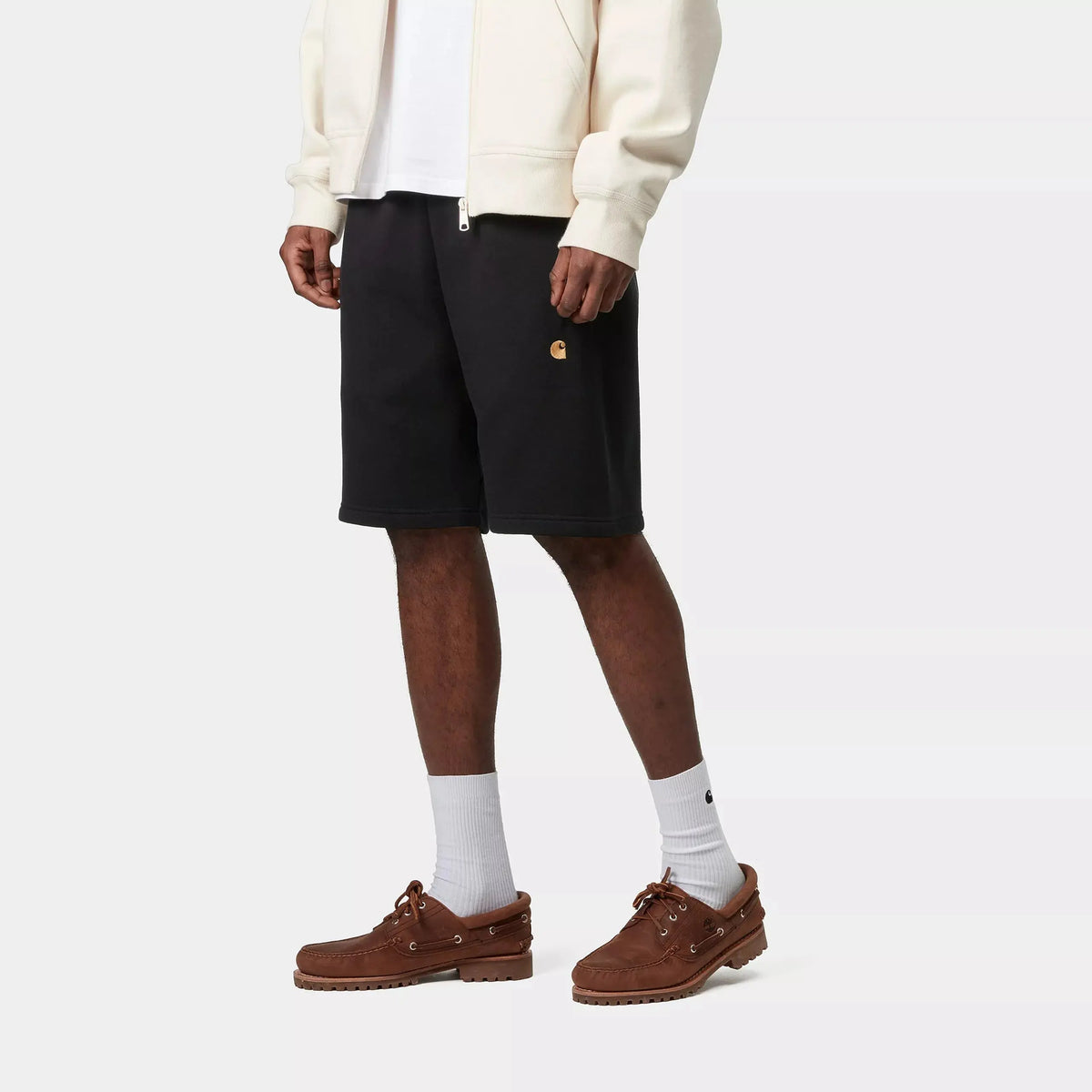 Short Chase noir vu de trois quarts sur le porté, logo C doré brodé sur la jambe et tombé ample sur la cuisse