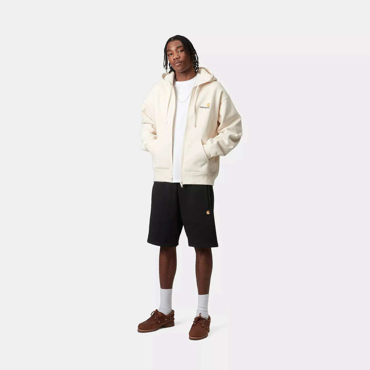 Silhouette complète avec le short Chase noir, coupe ample sur la cuisse et logo C doré visible sur la jambe