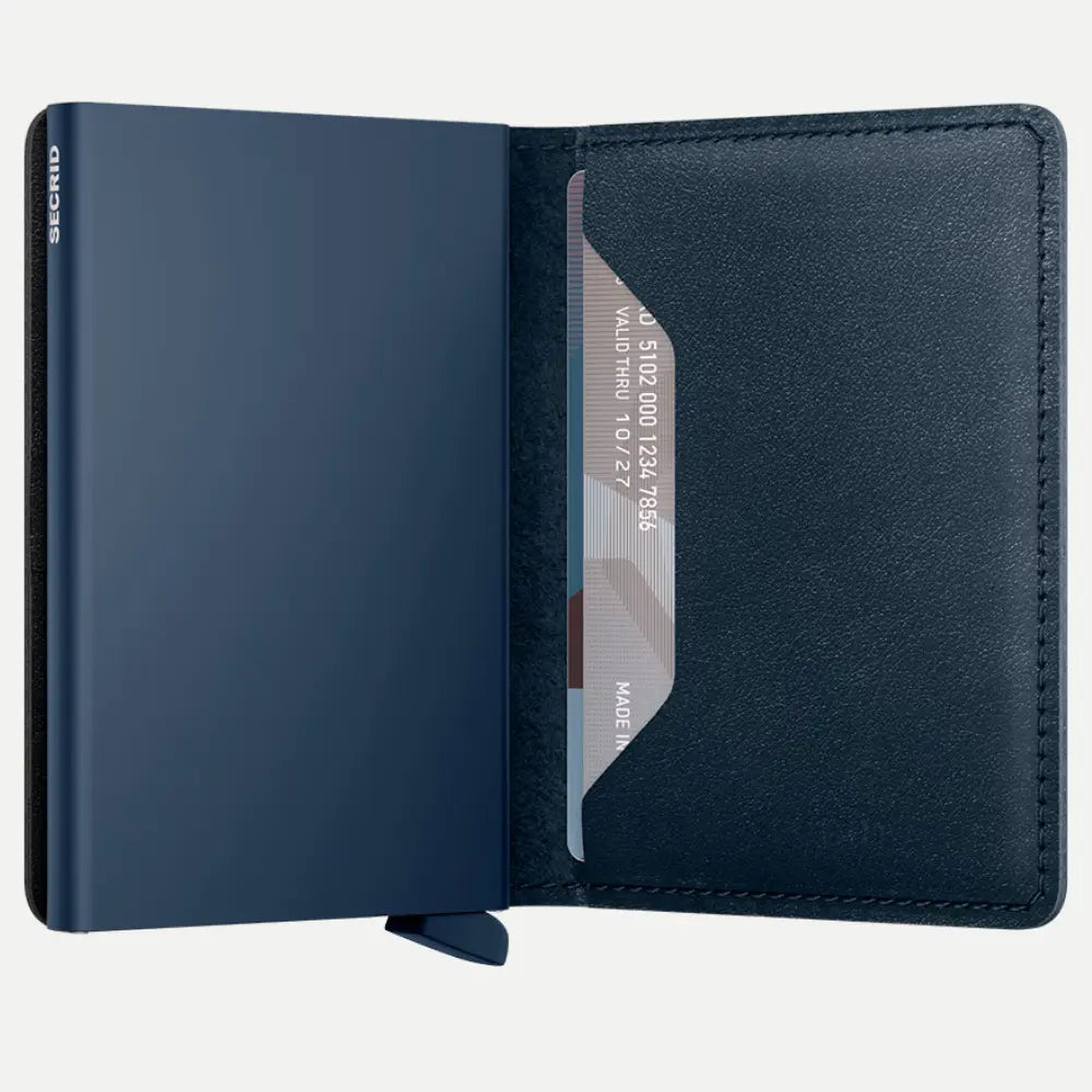 Portefeuille bleu marine ouvert à plat, boîtier assorti et carte glissée dans le rabat