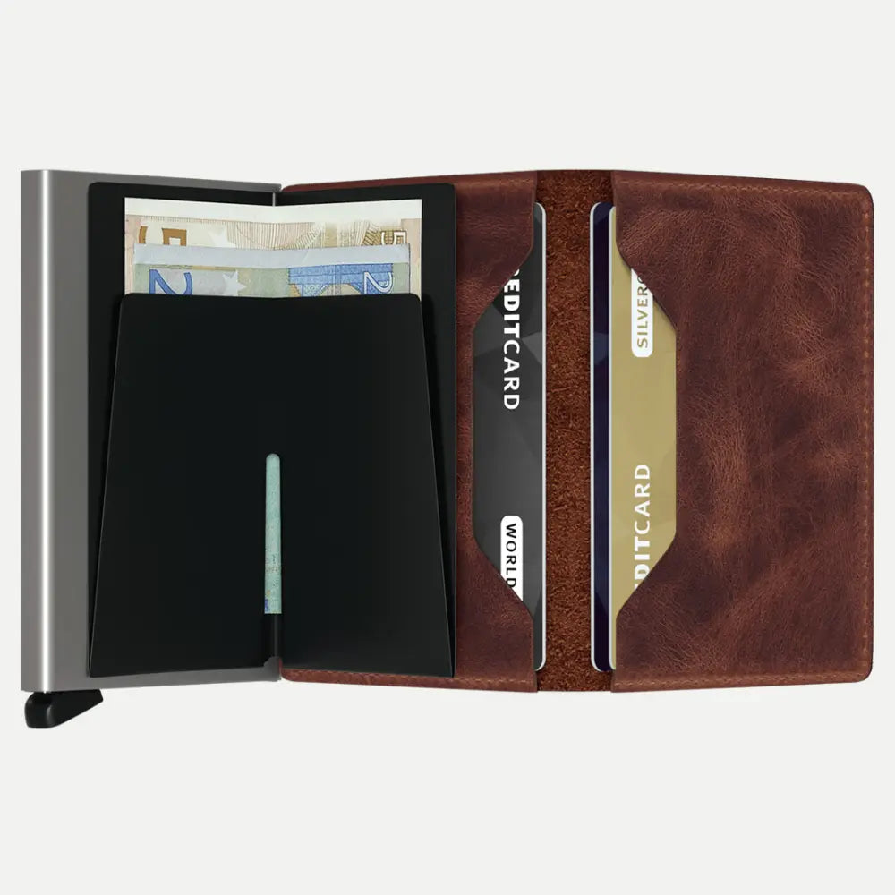 Intérieur du portefeuille marron : billets glissés derrière le boîtier métal et cartes rangées dans le cuir