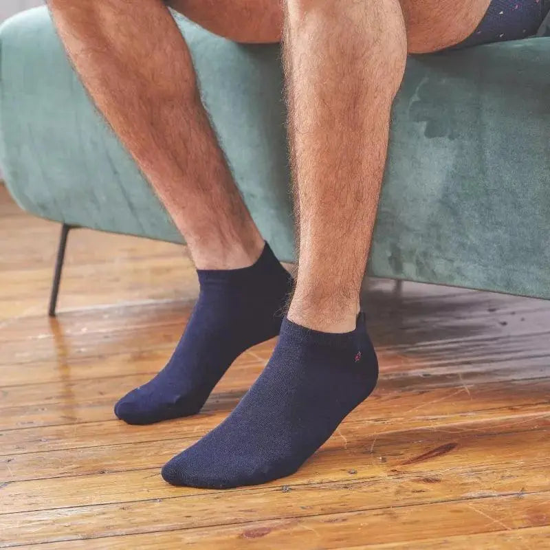 Socquettes bleu marine portées sur un parquet, coupe basse cachée sous la cheville